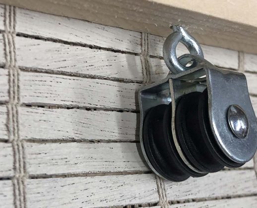 vue de près de la poulie de gauche du système d'enroulement d'un store en bois